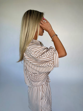 Woman wearing a striped outfit against a plain background