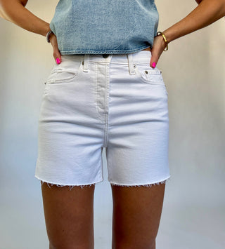 Person wearing light blue denim shorts and a matching top against a neutral background