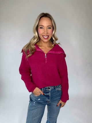 Woman wearing a pink magenta sweater with a white background
