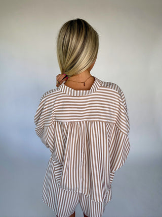 Person wearing a striped shirt and shorts set with a neutral background