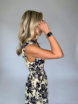 Woman wearing a floral dress against a plain background