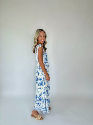 Woman wearing a floral dress against a plain background