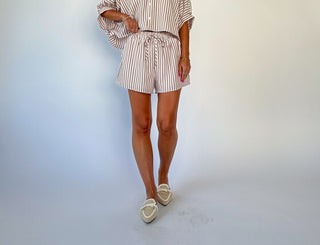 Person wearing a striped outfit with shorts on a plain background