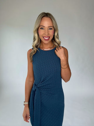 Woman wearing a blue dress against a plain background