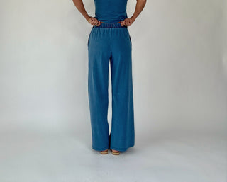 Person wearing a blue outfit with wide-leg pants on a white background