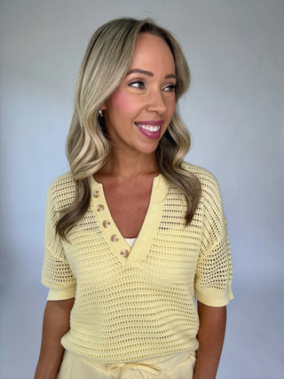 Woman wearing a yellow textured top against a plain background