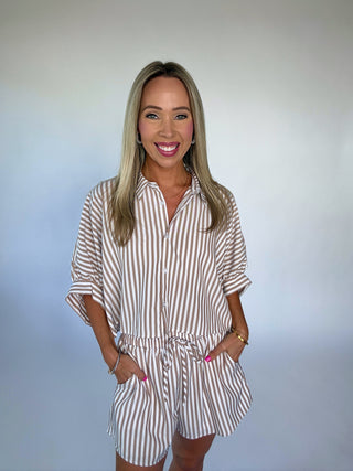 Woman wearing a striped romper against a plain background