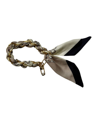 Bracelet with braided design and ribbon-like elements on a white background