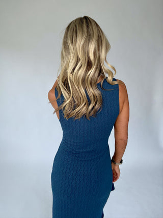 Woman wearing a blue dress with a plain background