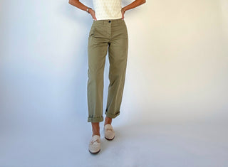 Person wearing olive green pants on a white background