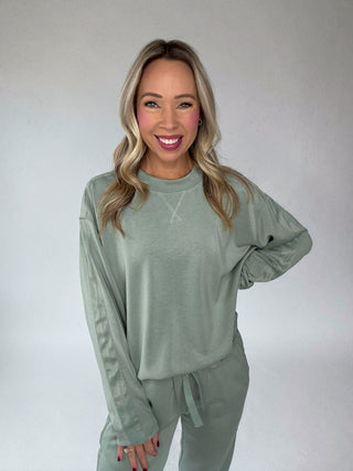 Woman wearing a green outfit against a plain background