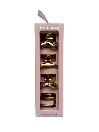 Pink hair box with gold hair accessories on a white background