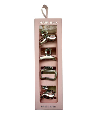 Pink hair box with hair accessories inside on a white background