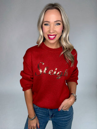 Woman wearing a red sweater with 'Mistletoe' text on a gray background