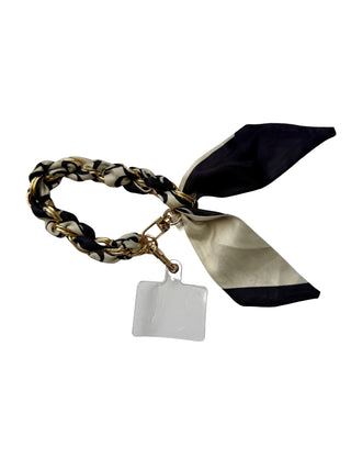 Bracelet with braided design, black and gold ribbon, and a tag on a white background